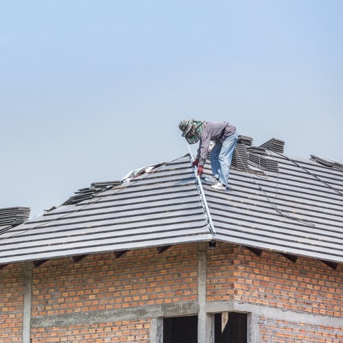 workers installing a new tile roof